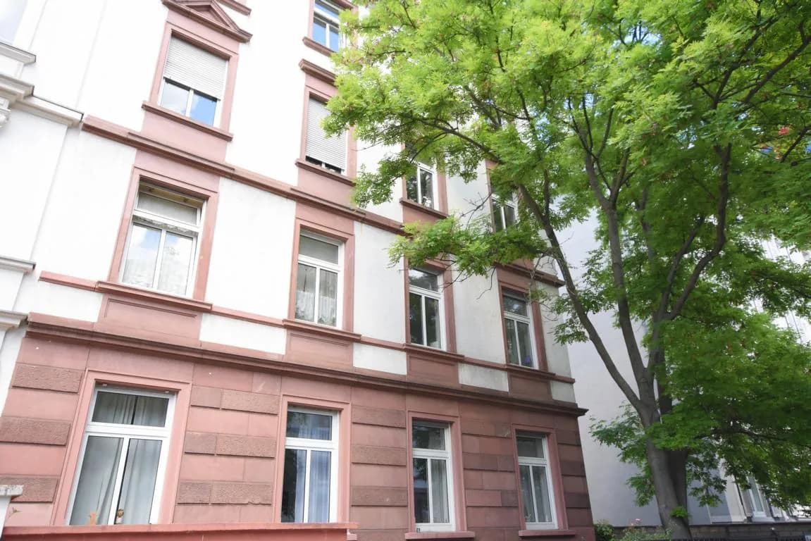 Altbaufassade mit rotem Sandstein und Baum davor in Frankfurt-Nordend